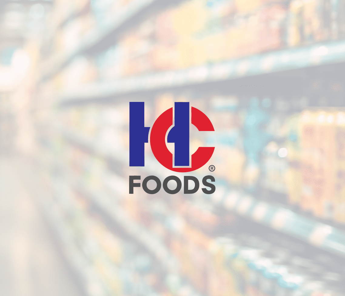 Centered against a blurred grocery store aisle, the HC Foods logo stands out in blue and red amid shelves of assorted products.