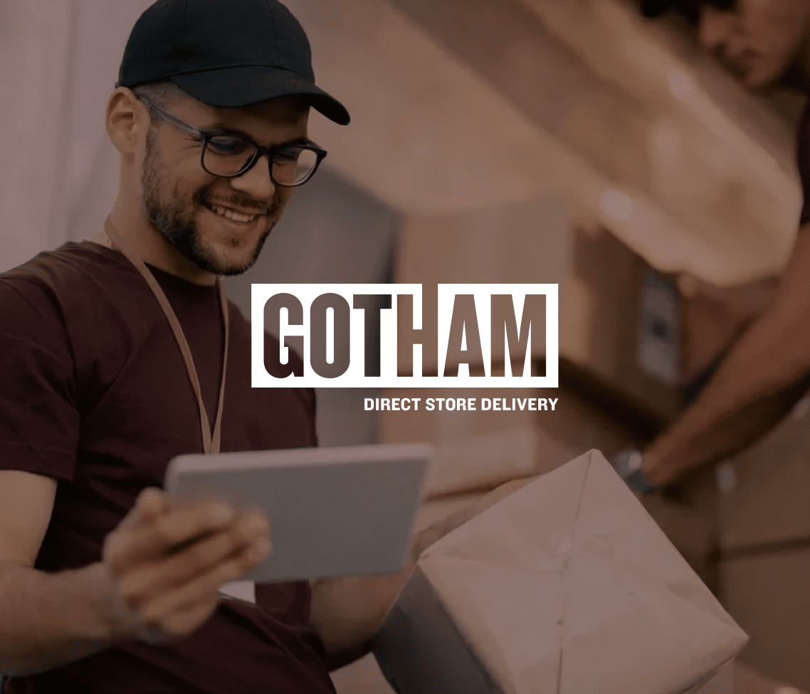 A cheerful delivery worker with glasses and a cap holds a tablet and package, while another moves boxes. GOTHAM DIRECT STORE DELIVERY text appears.